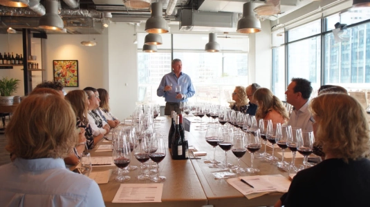 Sommelier leder vinprovning för en grupp runt ett bord i Malmö