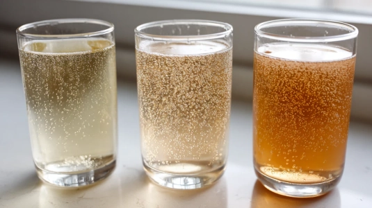 Tre olika glas med alkoholfritt bubbel i olika nyanser bredvid varandra