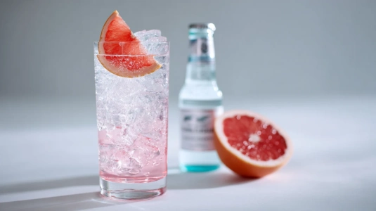 Gin och tonic med grapefruktskiva i stort glas med is