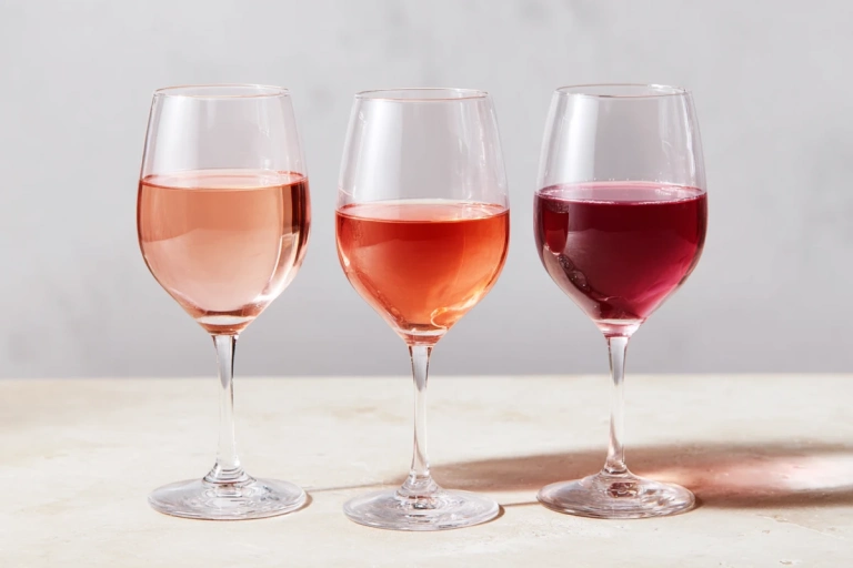Tre glas rosévin i olika nyanser från blekt rosa till djupt hallonrött