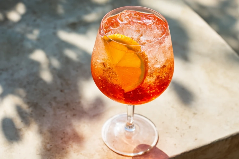 Aperol Spritz i ett stort vinglas med isbitar och apelsinskiva