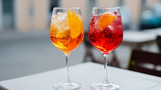 Två varianter av spritz bredvid varandra – en klassisk orange och en mörkare röd med Campari