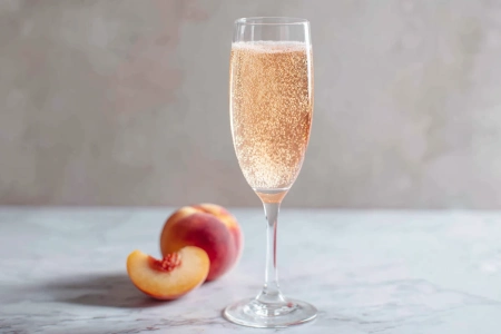 Bellini i champagneglas med ljus persikofärg och bubblor