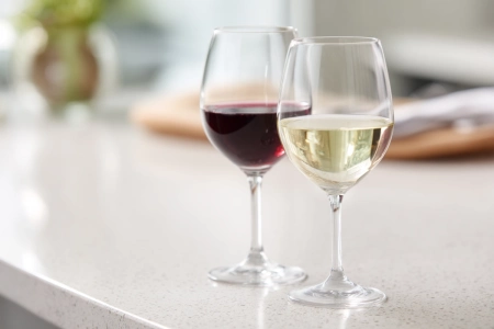 Glas rött vin bredvid glas vitt vin på en enkel yta