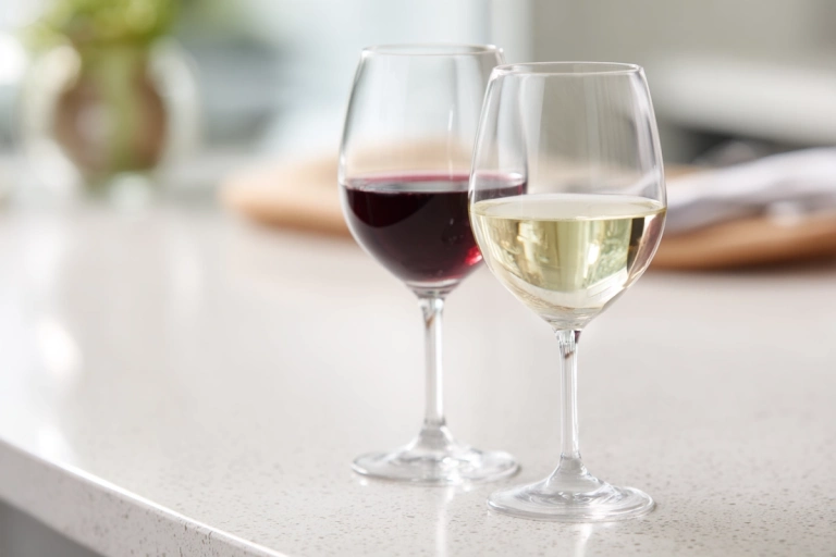 Glas rött vin bredvid glas vitt vin på en enkel yta