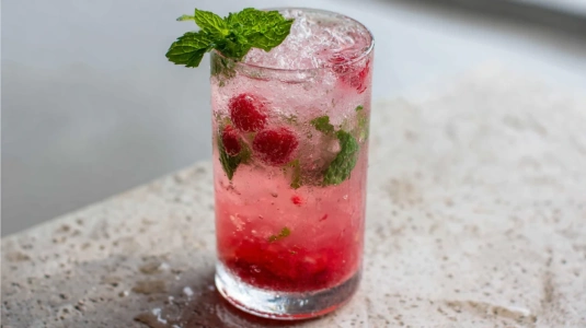 Bärmojito med hallon i highballglas med rosa färg och krossad is
