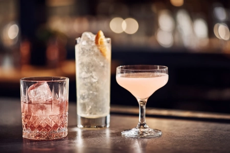 Tre cocktailglas på rad: rocks-glas, highballglas och coupéglas