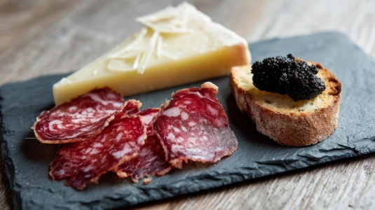 Skivor av coppa och manchego bredvid olivtapenad på rostat bröd