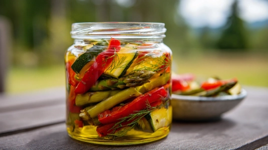 Marinerade grönsaker med grillad paprika, zucchini och sparris i en skål