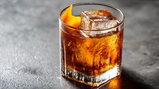 Rocks-glas med Old Fashioned och stor isbit sett uppifrån
