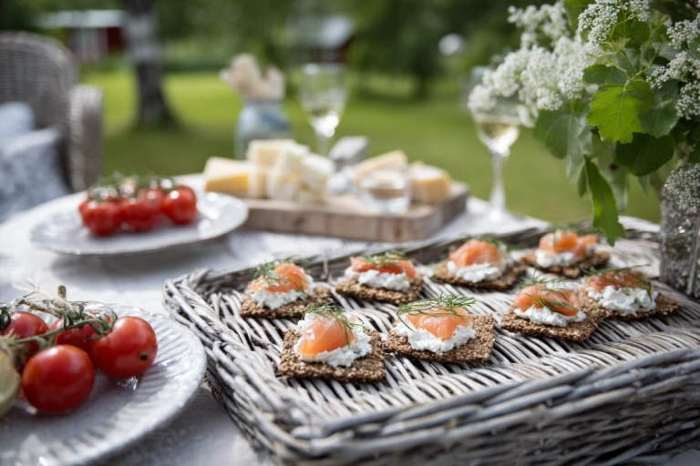Tilltugg uppdukat på ett bord utomhus en svensk midsommardag