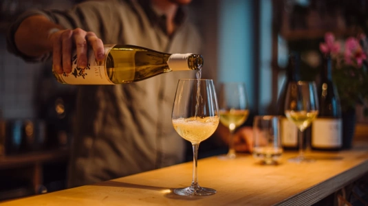 Bartender häller naturvin vid en vinbar