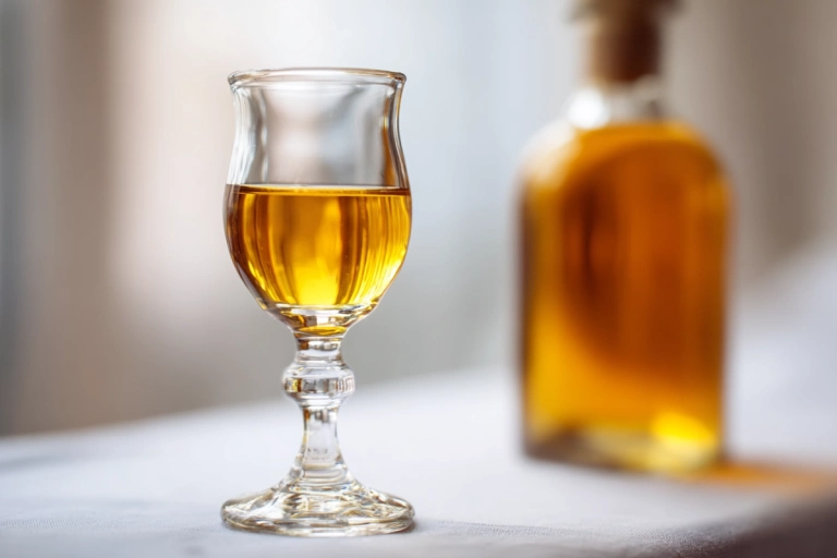 Dessertvin i litet glas med halvflaska i bakgrunden