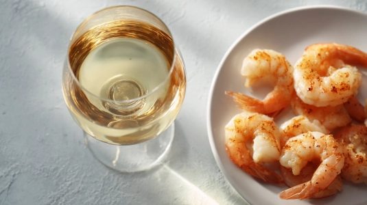 Glas med albariño bredvid tallrik med räkor