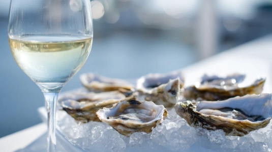 Färska ostron på is med glas albariño